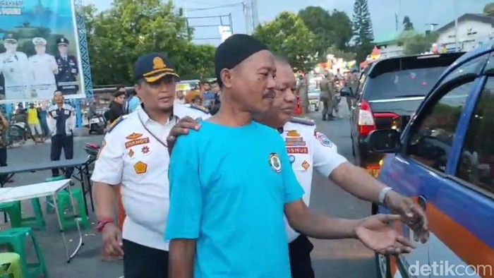 Petugas mengamankan juru parkir viral nuthuk tarif parkir di Alun-alun Kota Tegal, Senin (13/10/2025)