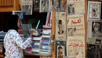 Pengunjung melihat koleksi buku di kios buku pasar Al-Azbakeya. Pasar ini menjadi destinasi budaya yang menghubungkan masa lalu dan masa depan literasi Mesir. Foto: REUTERS/Mohamed Abd El Ghany