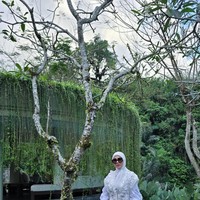 Syahrini memilih atasan lengan balon panjang yang dipadukan dengan vest senada dengan detail floral 3D. Ia juga melengkapi penampilannya dengan sepatu dan hijab putih. Foto: Instagram/@princessyahrini