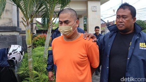 Ekspresi datar Sunardi saat digiring polisi ke ruang tahanan di Mapolsek Denpasar Barat, Senin (13/10/2025). (Aryo Mahendro/detikBali).