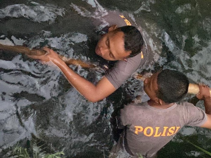 Anggota Polresta Cilacap mengatasi banjir di Perumahan Sidakaya Indah Soetomo Grand Village, Kelurahan Sidakaya, Cilacap Selatan, Senin (13/10/2025).