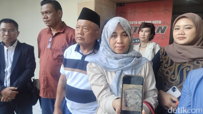Istri Yai Mim saat menunjukkan foto sajadah yang dibakar