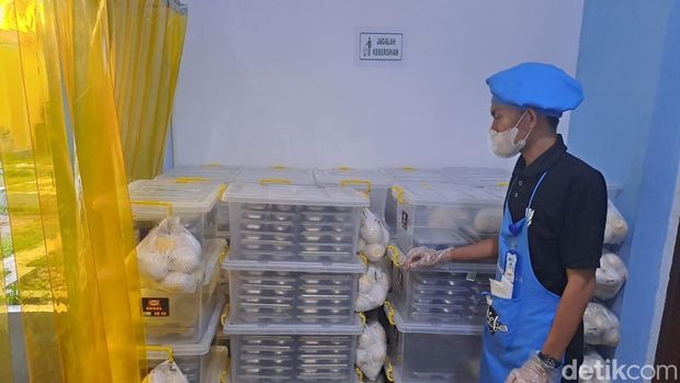 Ketua koordinator pemorsian mengecek boks berisi paket MBG sebelum didistribusikan ke sekolah.