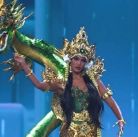 Crown-nya memukau dengan bentuk menyerupai mahkota kerajaan laut, dihiasi batu kristal dan detail ukiran menyerupai ombak dan sisik naga. Dari mahkota itu menjuntai untaian manik panjang berwarna keemasan, menambah kesan elegan dan magis. Foto: Instagram/@vinanggisitorus