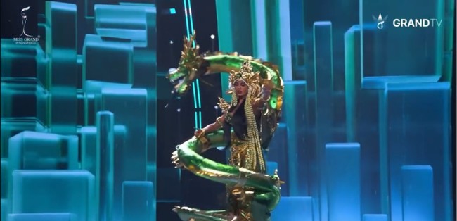 Kostum nasional wakil Indonesia hadir dalam dominasi warna emerald green dan gold, menciptakan aura mewah sekaligus mistis khas penguasa laut. Siluetnya menyerupai gaun mermaid dengan detail sculptural di bagian pinggang hingga ekor. Foto: Instagram/@vinanggisitorus