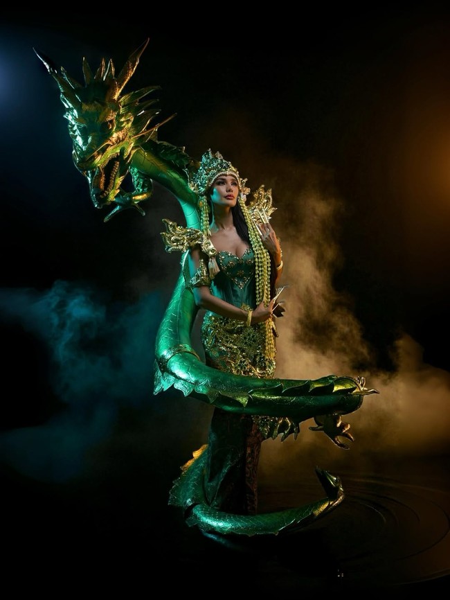 Setiap bagian kostum menampilkan kerajinan tingkat tinggi — mulai dari embellishment berkilau yang menyerupai sisik ikan, hingga struktur armor berwarna emas di bahu dan pinggang yang menambah kesan powerful. Ada perpaduan antara kelembutan laut dan kekuatan naga, menciptakan visual yang memadukan feminin dan fierce dalam satu tampilan. Foto: Instagram/@vinanggisitorus