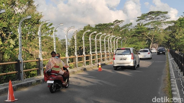 Pekerja memasang kerangka tiang pagar di sisi utara jembatan Penet Sangeh, Badung, sebelum nanti dipasang jaring kawat, Selasa (14/10/2025). (Agus Eka/detikBali)