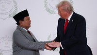 Presiden Amerika Serikat (AS) Donald Trump menyambut Presiden RI Prabowo Subianto di panggung berlatar Konferensi Tingkat Tinggi (KTT) Perdamaian Gaza Sharm El-Sheikh Peace 2025, di Mesir, Senin (13/10/2025). Trump tampak mengenakan setelan jas biru gelap. dan Prabowo mengenakan setelan jas abu. Foto: REUTERS/Suzanne Plunkett