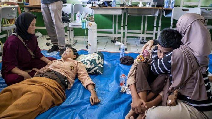Petugas mengevakuasi siswa yang diduga keracunan hidangan makan bergizi gratis (MBG) di SMPN 1 Cisarua, Cisarua, Kabupaten Bandung Barat, Jawa Barat, Selasa (14/10/2025). Berdasarkan keterangan pihak sekolah, sebanyak 54 siswa mengalami keracunan yang diduga akibat menyantap hidangan makan bergizi gratis pada Selasa (14/10) pagi. ANTARA FOTO/Abdan Syakura