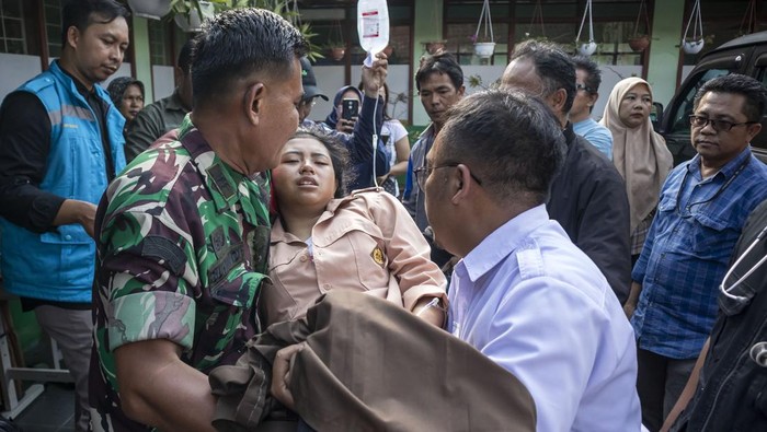 Petugas mengevakuasi siswa yang diduga keracunan hidangan makan bergizi gratis (MBG) di SMPN 1 Cisarua, Cisarua, Kabupaten Bandung Barat, Jawa Barat, Selasa (14/10/2025). Berdasarkan keterangan pihak sekolah, sebanyak 54 siswa mengalami keracunan yang diduga akibat menyantap hidangan makan bergizi gratis pada Selasa (14/10) pagi. ANTARA FOTO/Abdan Syakura