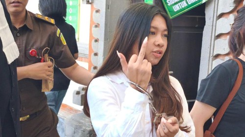 Selebgram Vienna Varella mengacungkan jari tengah ke arah wartawan seusai keluar dari ruang sidang PN Denpasar, Kamis (14/10/2025).