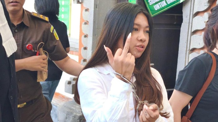 Selebgram Vienna Varella mengacungkan jari tengah ke arah wartawan seusai keluar dari ruang sidang PN Denpasar, Kamis (14/10/2025).