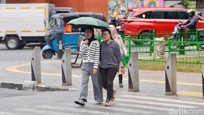 Suhu Panas Menggila, BMKG Bongkar Faktor Utamanya Sejumlah warga beraktivitas di luar ruangan di bawah teriknya matahari, Jakarta, Selasa (14/10/2025).