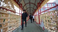 Warga tampak beraktivitas di Jembatan Penyeberangan Orang (JPO) Kenari, Jakarta, Selasa (14/10/2025).   