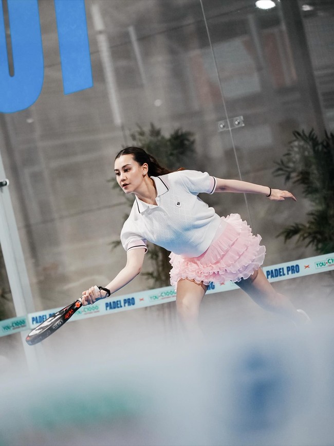Raket padel berdesain bold hitam-putih ikut memperkuat kesan chic dan modern, melengkapi outfit tanpa kehilangan fungsi. Foto: Instagram/@aaliyah.massaid