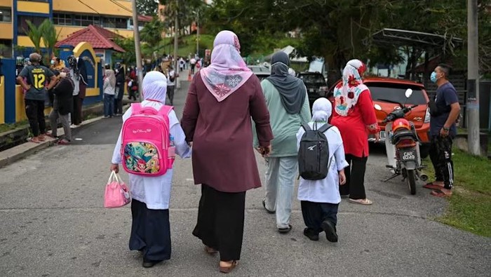 Parents send their children on the first day of elementary school in Standard One (Primary One) at a local national school, on the start of the new school year in Karak, Malaysias Pahang state on Mar 21, 2022. (File photo: AFP/Mohd Rasfan)