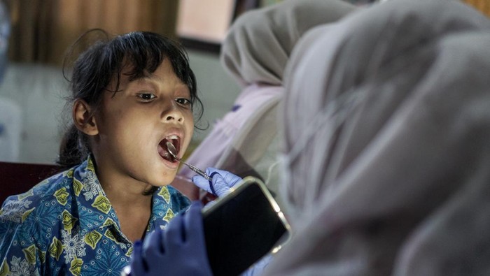 Petugas medis memeriksa gigi siswa pada kegiatan Pemeriksaan Gigi Gratis di SD Negeri II Sumber, Solo, Jawa Tengah, Rabu (15/10/2025). Kegiatan tersebut untuk deteksi dini masalah kesehatan gigi pada siswa sekaligus upaya memberikan edukasi dan menumbuhkan kesadaran kepada anak mengenai pentingnya menjaga kesehatan gigi dan mulut. ANTARA FOTO/Mohammad Ayudha/bar