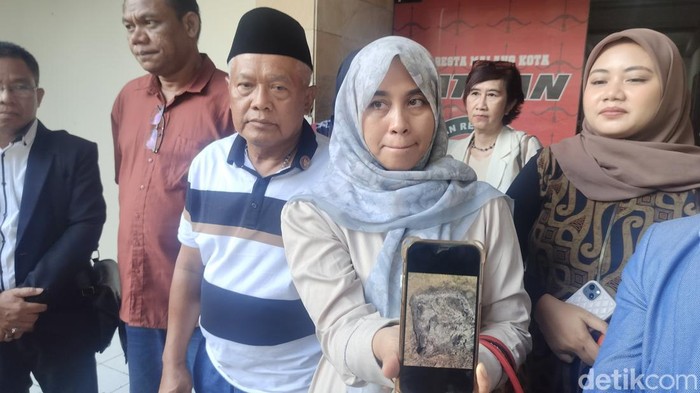 Istri Yai Mim, Ines menunjukkan sisa sajadah yang dibakar.