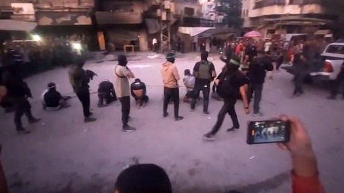 This image grab from a handout video released by the Hamas-run al-Aqsa TVs Telegram channel on October 13, 2025, shows armed Hamas fighters standing behind blindfolded, bound and kneeling men as a crowd surrounds them in a street in Gaza City. The Hamas militant group has published an online video showing its fighters executing eight blindfolded, bound and kneeling men in the street. Hamass armed groups are carrying out a campaign against Palestinian criminal gangs and clans in Gaza in the wake of a ceasefire with Israeli forces. (Photo by Al-Aqsa TV / AFP) / RESTRICTED TO EDITORIAL USE - MANDATORY CREDIT 