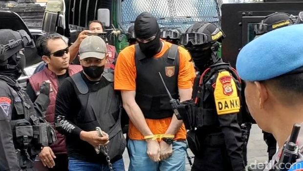 Para tersangka saat turun dari mobil rantis Brimob lalu digiring ke ruangan di Kejari Badung, Rabu (15/10/2025).