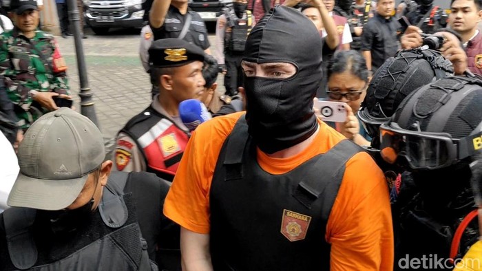 Para tersangka saat turun dari mobil rantis Brimob lalu digiring ke ruangan di Kejari Badung, Rabu (15/10/2025).