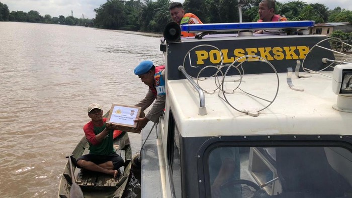 Polsek Kawasan Pelabuhan memberikan bansos kepada nelayan di pesisir Sungai Siak, Rabu (15/10/2025).