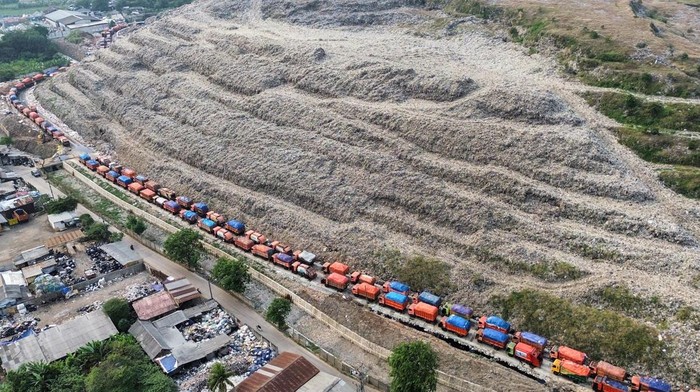 Pekerja membawa keranjang sampah di Tempat Pengolahan Sampah Terpadu (TPST) Bantargebang, Bekasi Jawa Barat, Rabu (15/10/2025). Presiden Prabowo Subianto menerbitkan Peraturan Presiden (Perpres) Nomor 109 Tahun 2025 tentang penanganan sampah perkotaan melalui pengolahan sampah menjadi energi terbarukan berbasis teknologi ramah lingkungan untuk mengatasi timbunan sampah hingga puluhan juta ton per tahun. ANTARA FOTO/Fakhri Hermansyah