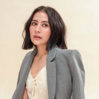 Untuk pemotretan kali ini Prilly mengenakan makeup yang ringan dan natural, menonjolkan pesona wajah aslinya. Kulitnya terlihat segar dengan efek dewy, dilengkapi rona pipi lembut dan lipstik nude yang natural. Riasan mata dibuat minimalis, hanya mempertegas bulu mata agar tetap terlihat hidup tanpa berlebihan. Foto: Instagram/@prillylatuconsina96
