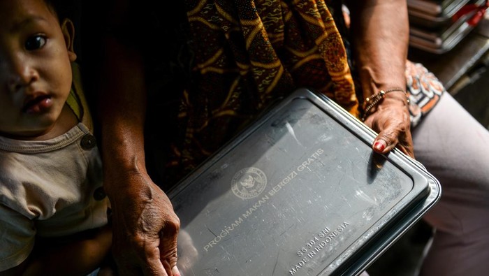 Ibu dari seorang balita menerima Makanan Bergizi Gratis (MBG) untuk di Desa Cileunyi Wetan, Kabupaten Bandung, Jawa Barat, Rabu (15/10/2025). Pemerintah Desa Cileunyi Wetan telah mendistribusikan MBG kepada 300 warga yang terdiri dari balita, ibu hamil dan ibu menyusui sejak 1 Oktober 2025 yang diharapkan mampu mengentaskan gizi buruk dan anak stunting di wilayah tersebut. ANTARA FOTO/Raisan Al Farisi/bar