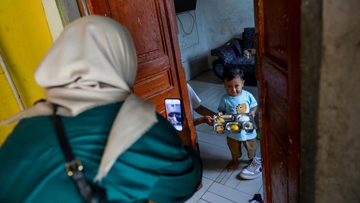 Ibu dari seorang balita menerima Makanan Bergizi Gratis (MBG) untuk di Desa Cileunyi Wetan, Kabupaten Bandung, Jawa Barat, Rabu (15/10/2025). Pemerintah Desa Cileunyi Wetan telah mendistribusikan MBG kepada 300 warga yang terdiri dari balita, ibu hamil dan ibu menyusui sejak 1 Oktober 2025 yang diharapkan mampu mengentaskan gizi buruk dan anak stunting di wilayah tersebut. ANTARA FOTO/Raisan Al Farisi/bar