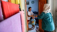 Ibu dari seorang balita menerima Makanan Bergizi Gratis (MBG) untuk di Desa Cileunyi Wetan, Kabupaten Bandung, Jawa Barat, Rabu (15/10/2025). Foto: ANTARA FOTO/Raisan Al Farisi