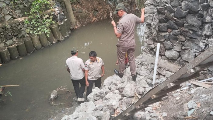 Satpol PP Badung melihat pembongkaran bangunan pondasi tanggul yang mepet aliran sungai di Batu Belah, Desa Pererenan, Kecamatan Mengwi. (Dok Satpol PP Badung)