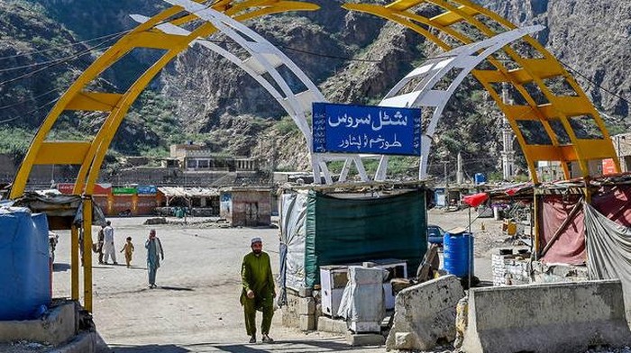 A man walks across a bus stand at the Pakistan-Afghanistan border town of Torkham on October 13, 2025, amid cross-border clashes between the two countries. (AFP)