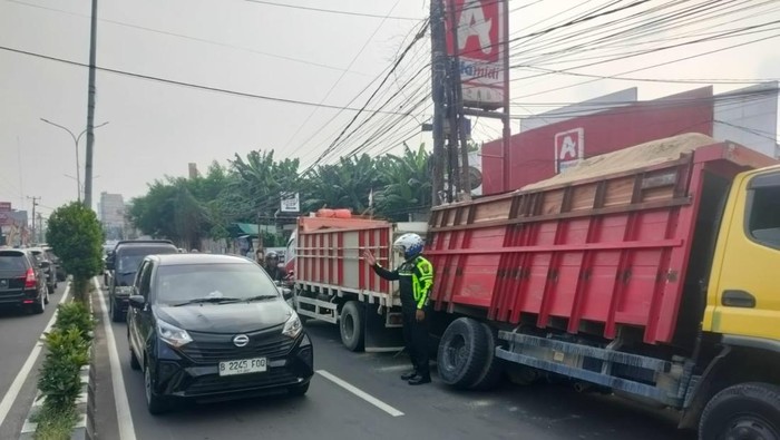 Truk bermuatan pasir terperosok ke lubang galian di Jalan Kartini, Depok (dok. ist)