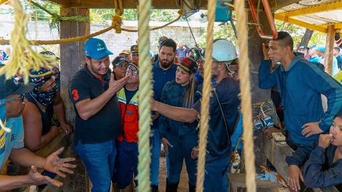 This handout picture released by the Government of Bolivar press office shows Bolivar State Governor Yulisbeth Garcia (C) speaking with relatives of miners who died after floods reached a gold mine in the town of El Callao town, Bolivar State, Venezuela, on October 14, 2024. At least 14 miners have died in floods caused by heavy rain in eastern Venezuela, rescue workers said Tuesday. The workers were underground when heavy rains fell on the region which borders both Guyana and Brazil, flooding the mine. (Photo by Bolivar Government / AFP) / RESTRICTED TO EDITORIAL USE - MANDATORY CREDIT 