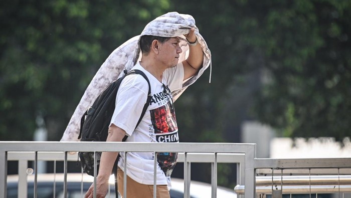 Warga menggunakan payung saat cuaca terik di kawasan Bundaran HI, Jakarta, Rabu (15/10/2025). Badan Meteorologi, Klimatologi, dan Geofisika (BMKG) mengungkap fenomena cuaca panas yang melanda sebagian besar wilayah Indonesia disebabkan posisi gerak semu matahari yang pada Oktober berada di selatan ekuator dengan suhu maksimal 36,7 derajat celsius, dan diprakirakan akan terjadi hingga November 2025. ANTARA FOTO/Sulthony Hasanuddin