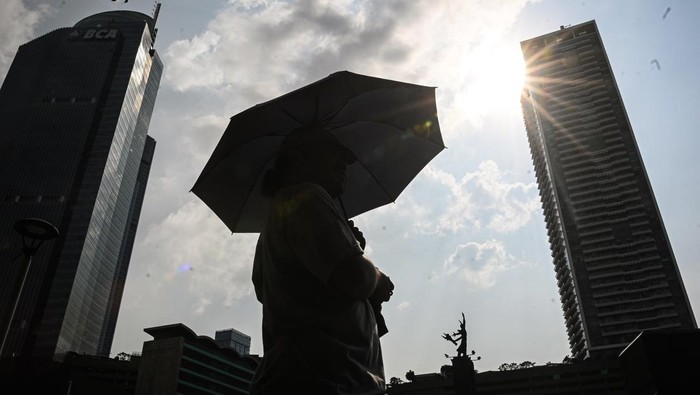 Warga menggunakan payung saat cuaca terik di kawasan Bundaran HI, Jakarta, Rabu (15/10/2025). Badan Meteorologi, Klimatologi, dan Geofisika (BMKG) mengungkap fenomena cuaca panas yang melanda sebagian besar wilayah Indonesia disebabkan posisi gerak semu matahari yang pada Oktober berada di selatan ekuator dengan suhu maksimal 36,7 derajat celsius, dan diprakirakan akan terjadi hingga November 2025. ANTARA FOTO/Sulthony Hasanuddin