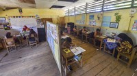 Guru kelas V dan VI mengajar di ruang kelas yang disekat tripleks di SDN 94 Lagan Ulu, Geragai, Tanjung Jabung Timur, Jambi, Kamis (16/10/2025).