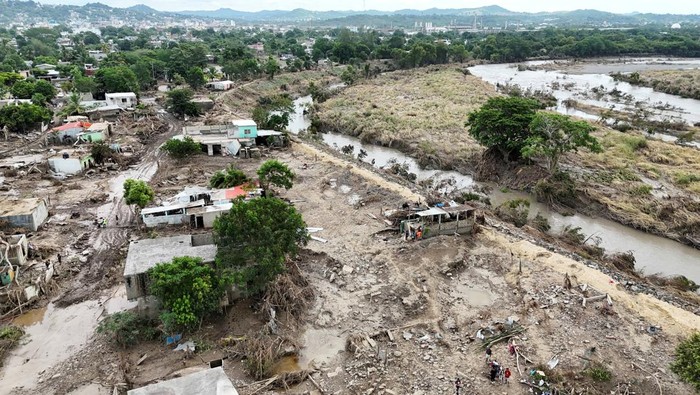 Francisco Salvador and Eduardo Gonzales look out from their home following torrential rains, in Poza Rica, Mexico, October 15, 2025. REUTERS/Henry Romero