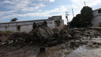 Sebuah kendaraan terjebak di tumpukan lumpur dan puing di Poza Rica, Meksiko, Rabu (15/10/2025). Hujan deras menyebabkan kerusakan parah pada fasilitas umum dan rumah. REUTERS/Henry Romero 