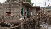 Francisco Salvador dan Eduardo Gonzales melihat kondisi rumah mereka pascahujan deras di Poza Rica, Meksiko, Rabu (15/10/2025). Warga setempat mulai membersihkan dan memperbaiki kerusakan. REUTERS/Henry Romero 