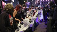 Demonstran membentangkan spanduk di hadapan barisan polisi saat aksi mogok umum di Madrid, Spanyol, Rabu (15/10/2025). Spanduk berisi seruan dukungan bagi warga Gaza. REUTERS/Violeta Santos Moura 