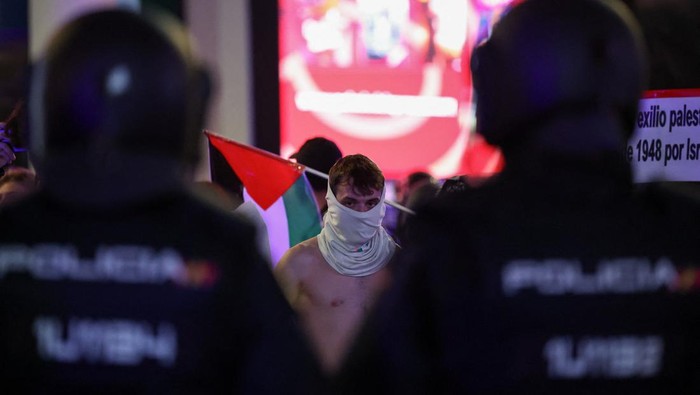 People walk past police officers guarding a McDonald's restaurant during a general strike called by Spanish unions in solidarity with Palestinians in Gaza, in Madrid, Spain, October 15, 2025. REUTERS/Violeta Santos Moura