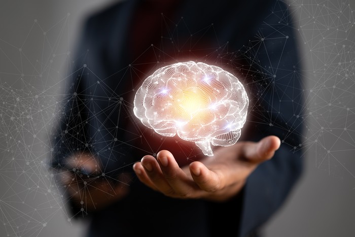 ilustrasi otak Businessman holding human brain and icon customer digital network with effective business mindset on paper texture background