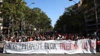 Massa mengangkat spanduk bertuliskan “Against genocidal imperialism, Free Palestine” saat aksi mogok umum di Barcelona, Spanyol, Rabu (15/10/2025). Aksi ini digelar serikat buruh Spanyol sebagai solidaritas untuk warga Palestina di Gaza. REUTERS/Albert Gea  