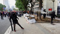 Polisi antihuru-hara menyemprotkan gas merica ke arah demonstran dalam aksi mogok umum di Barcelona, Spanyol, Rabu (15/10/2025). Bentrokan pecah ketika aparat membubarkan massa pro-Palestina. REUTERS/Albert Gea  