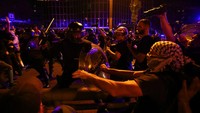 Massa bentrok dengan polisi antihuru-hara saat aksi mogok umum di Barcelona, Spanyol, Rabu (15/10/2025). Ketegangan meningkat saat aparat berusaha mengendalikan situasi. REUTERS/Albert Gea  