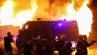 Api berkobar di belakang kendaraan polisi saat aksi mogok umum di Barcelona, Spanyol, Rabu (15/10/2025). Suasana tegang mengiringi demonstrasi solidaritas untuk Palestina. REUTERS/Albert Gea  
