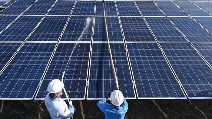Petugas membersihkan panel Pembangkit Listrik Tenaga Surya (PLTS) on grid Sengkol kapasitas 7 megawatt peak (MWp) di Sengkol, Praya, Lombok Tengah, NTB, Kamis (16/10/2025). Hingga saat ini PLN UIW NTB mengelola 19 unit pembangkit energi baru terbarukan (EBT) dengan total kapasitas 37,604 MW yang terdiri dari 56,2 persen PLTS dan 43,8 persen Pembangkit Listrik Tenaga Mikro Hidro (PLTMH) dengan rata-rata produksi sebesar 13,61 gigawatt hour (GWh) per bulan. ANTARA FOTO/Ahmad Subaidi
