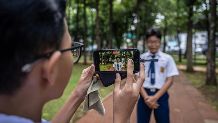 Pelajar memanfaatkan akses internet publik (JakWiFi) milik Pemprov DKI Jakarta untuk belajar di Taman Puring, Jakarta, Kamis (16/10/2025). Pemerintah terus berupaya menciptakan ruang digital yang ramah anak salah satunya melalui penerbitan Peraturan Pemerintah tentang Tunas Anak Indonesia (PP Tunas) yang mendorong peningkatan literasi digital, keamanan siber serta partisipasi anak dalam ekosistem digital yang sehat. ANTARA FOTO/Bayu Pratama S